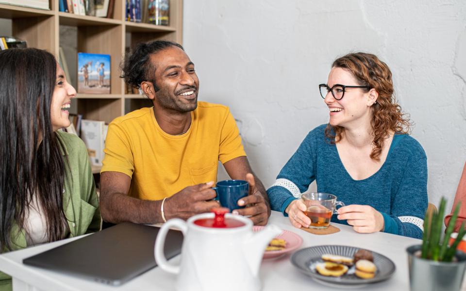 Three colleagues having tea and biscuits