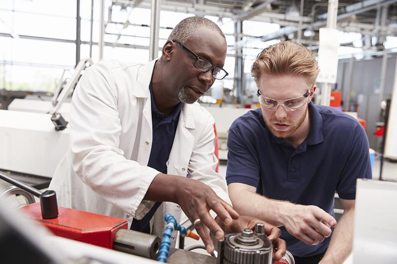 Older engineer working with an engineering apprentice