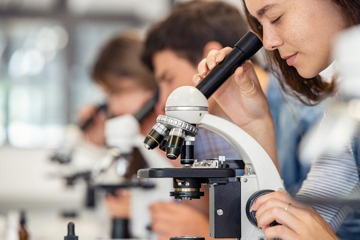A student uses a microscope in a lab