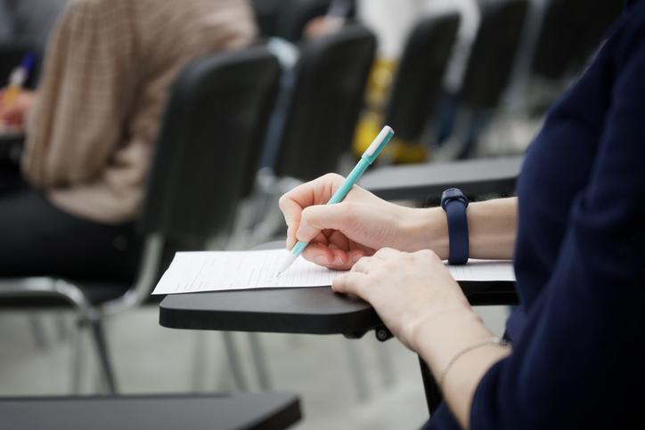 A student takes an exam at a desk