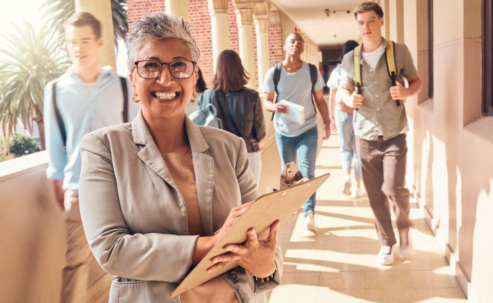 A smiling university professor in a campus hallway