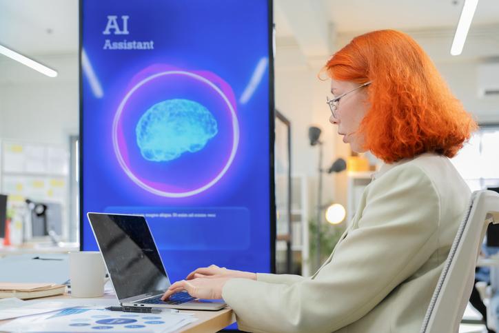A woman works at a laptop in a library setting