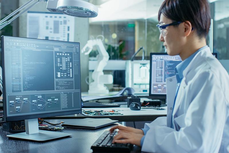 Asian scientist working at computer