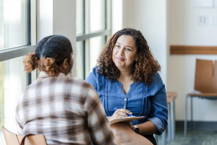 A psychology student providing counselling to a patient in a clinic