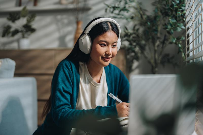 Young female Asian student doing an online course