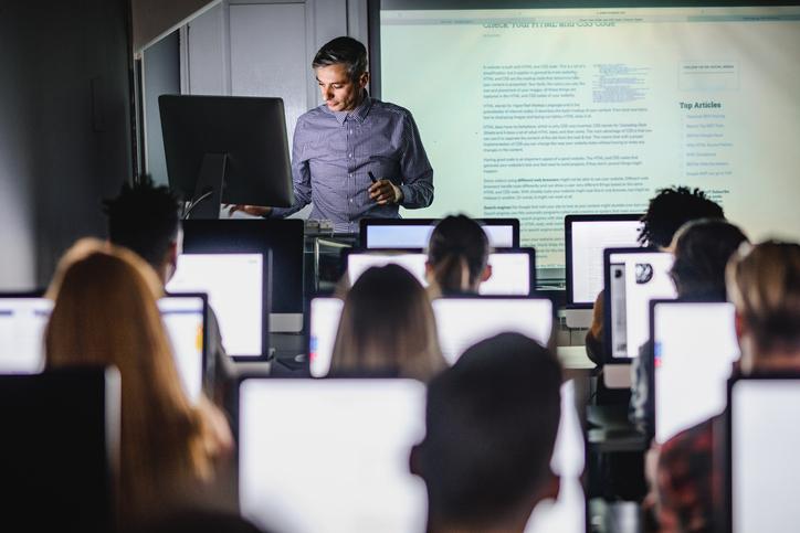 A professor teaches from the front of class