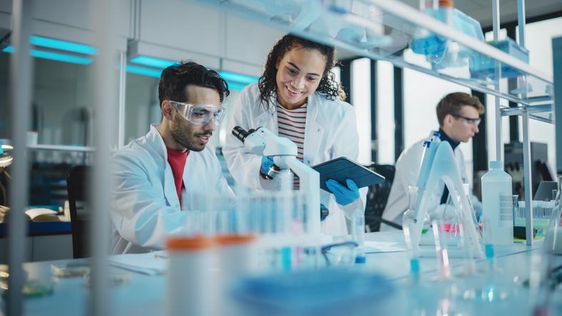 Researchers work together over a microscope