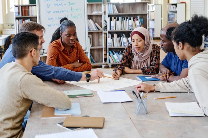 Teachers and students working on a project together in the library