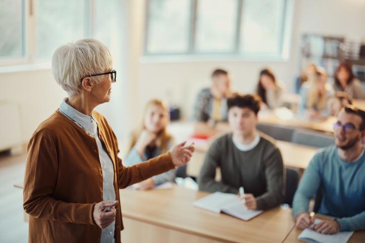 A teacher talks at the front of class