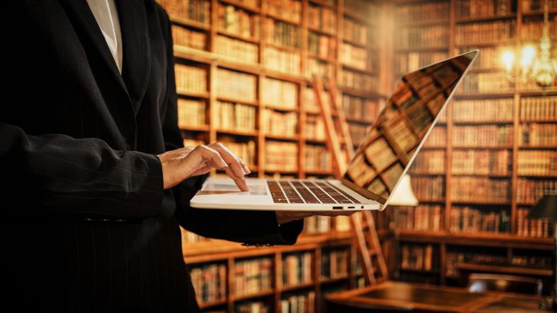 A researcher uses a laptop inside the library
