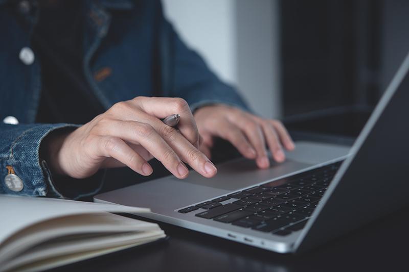 Female student writing on laptop
