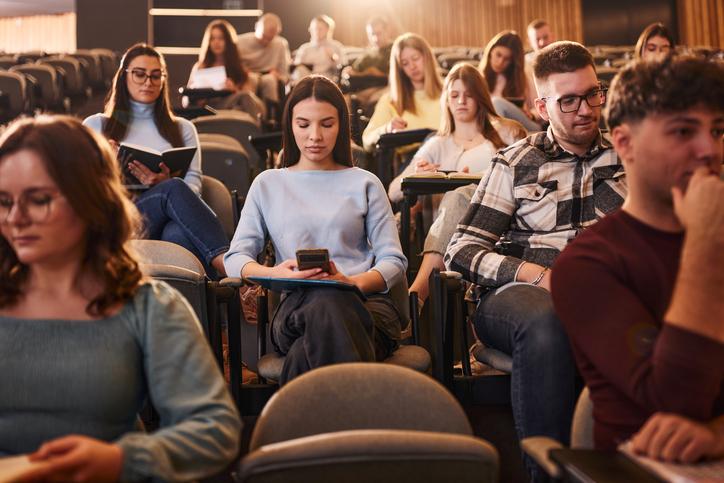 Students look at their phones in the lecture hall