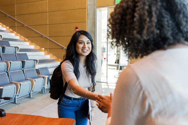 A staff member welcomes a student 