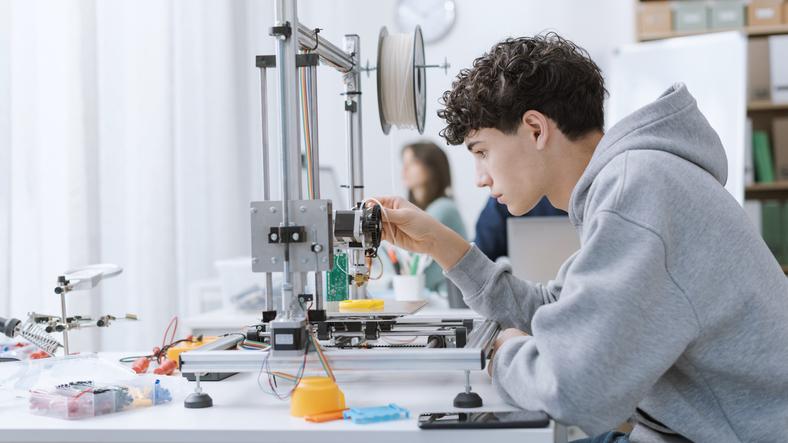 An engineering student fixing a machine in class