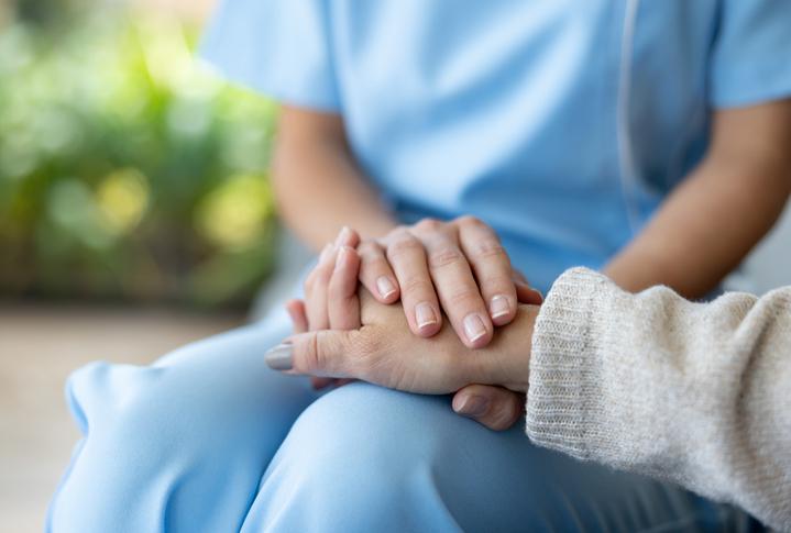 One person holds another's hand