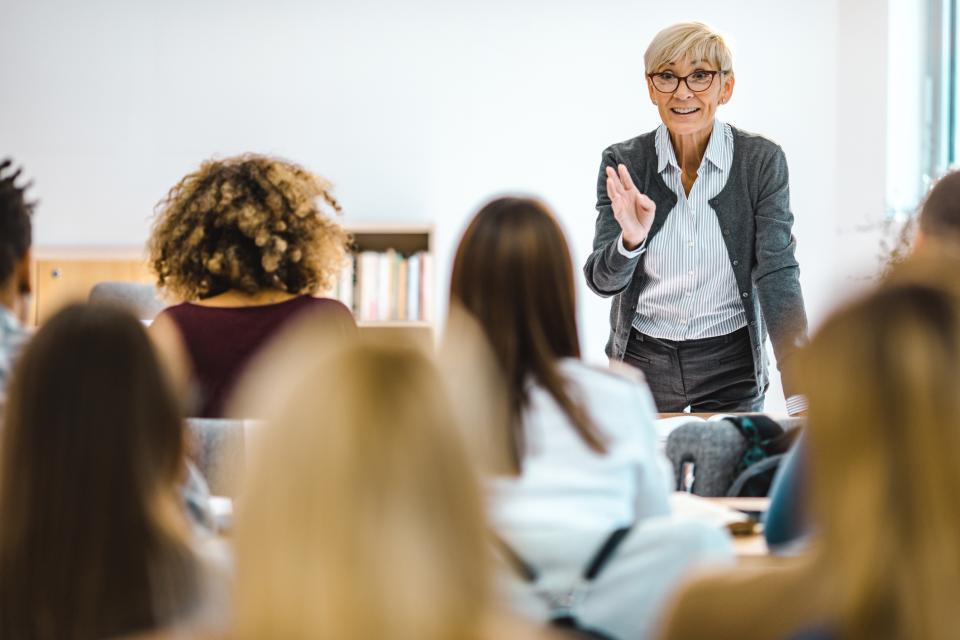 Mature female university teacher talking to a class