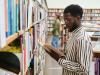 Male student choosing a book in his university library