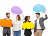 Group of four multi-racial people holding speech balloons