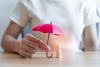 Woman holding small umbrella over wooden figure