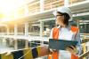 Female construction worker surveying a building