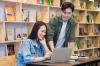 East asian students in a library working together