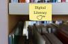 A sign saying "digital literacy" hung up on a shelf with books behind it