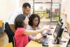 Multiracial group of three people looking at a computer