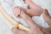 Newborn baby holding mother's hand