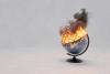A globe on fire, belching smoke