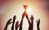 Hands hold a trophy aloft
