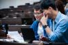 Two language students reading a physical document