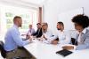 A hiring panel interviewing a candidate at a table