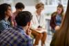 Students sitting in a circle haveing a discussion with a teacher