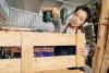 Young woman with a drill assembling a wooden bookcase