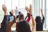 Participants in a seminar raise their hands