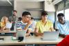 A group of students at a table looking at their screens