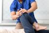 A physiotherapist moves a patient's leg