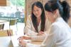 Two Chinese students working together on a latop
