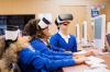 Three school children in class with VR headsets on