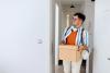 A new students arriving at his accommodation with a box of belongings