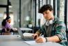 Young male college student studying in library