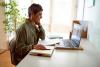 female mature-age online student working at laptop