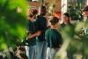 A group of students wearing green t shirts discussing a sustainability initiative