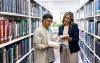 A teacher advising a student on a reading in the library