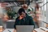 A man at a desk rubs his forehead
