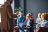 An academic laughs in a meeting